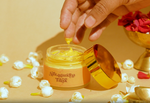 Hand taking a small amount of Deiveegaa Ashtagandha Tilak paste from the jar